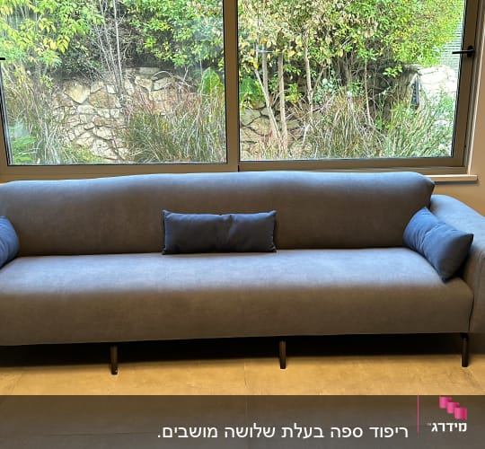 ספה אפורה עם כריות קטנות על משטח מרוצף